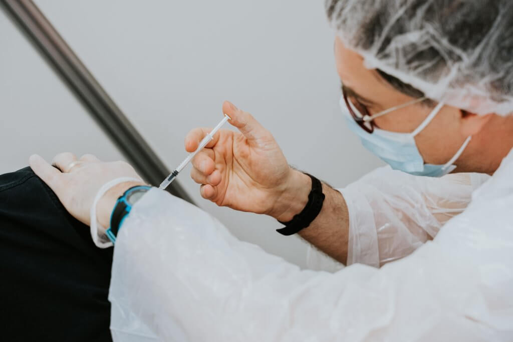 Person vaccining someone arm