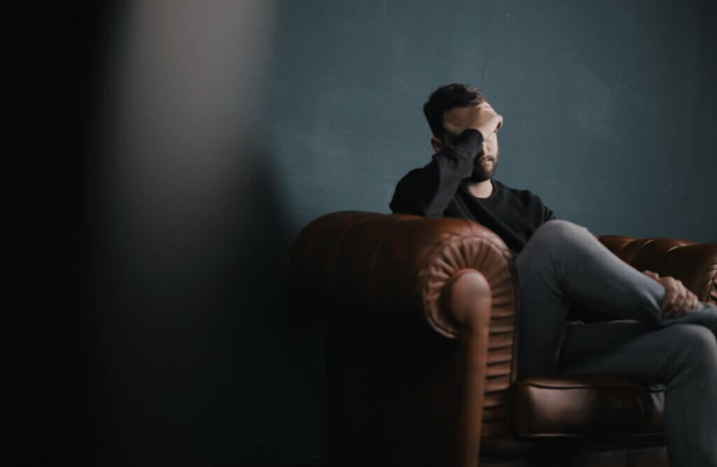 Man sets in chair meeting with person after suffering mental health