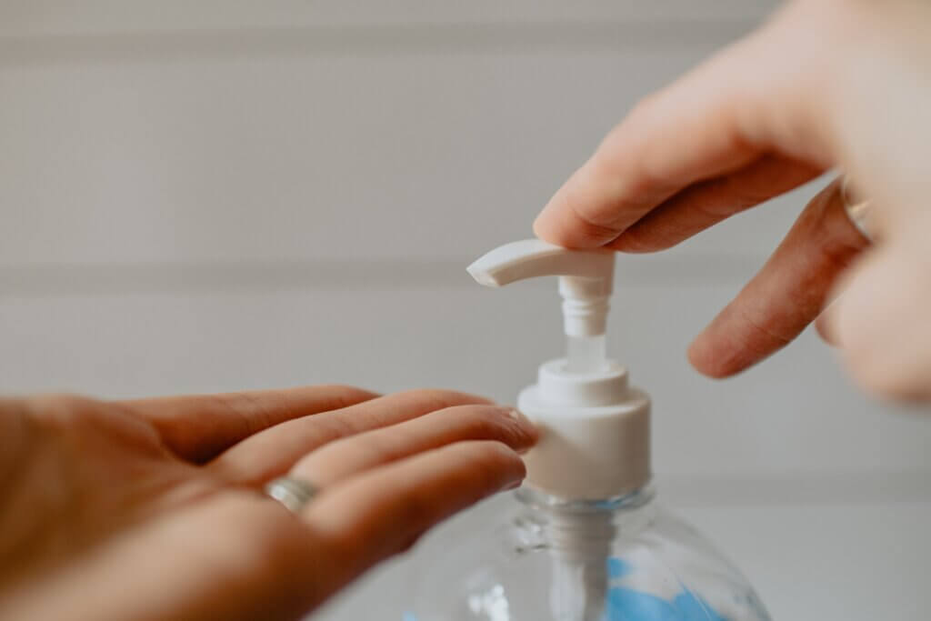 Person applying sanitiser to their hands as the enter workplace,